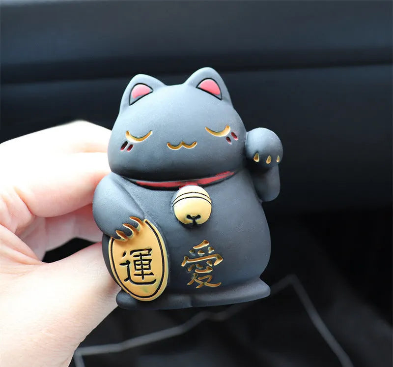 Black and white resin fortune cat decorative clip for car air conditioning vent with aromatherapy function.