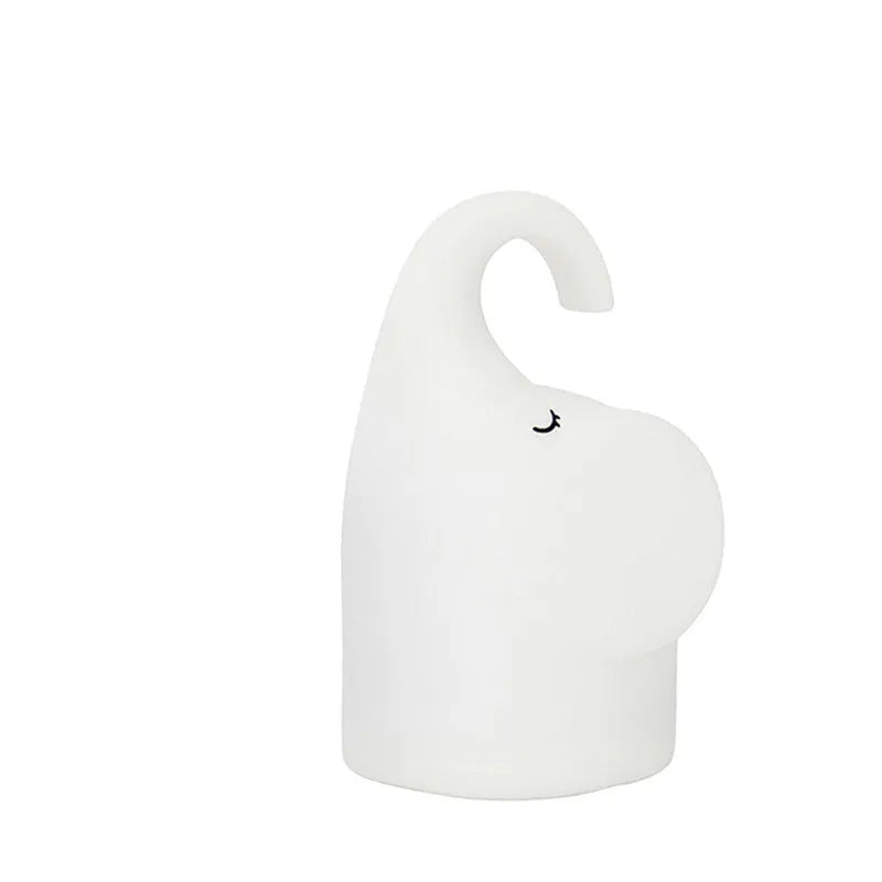DOMI Elephant-shaped silicone night light with warm white LED glow on a bedside table.