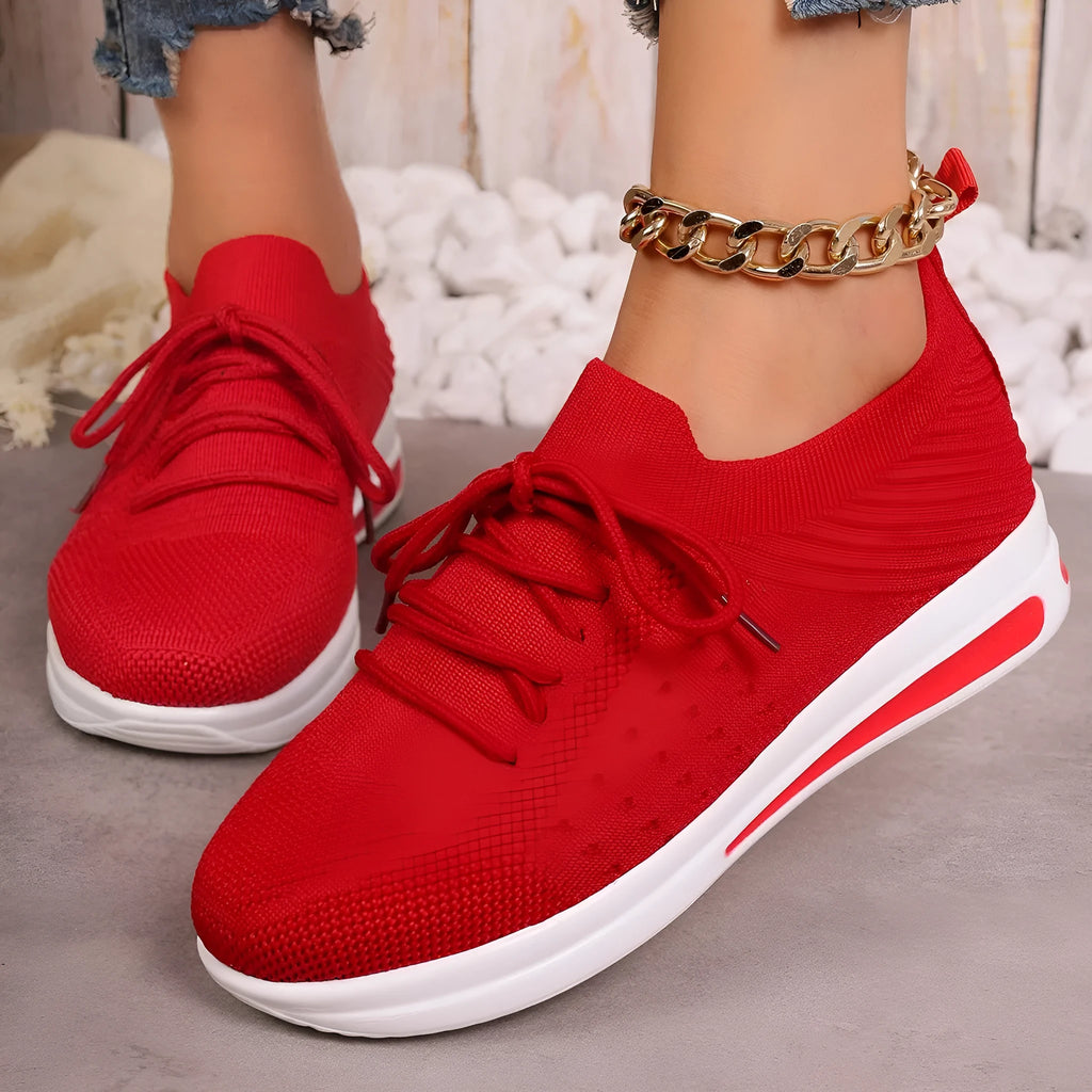 Women's low-top lace-up sneakers in red, black, or blue with a fly-knit texture and round toe.