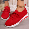 Women's low-top lace-up sneakers in red, black, or blue with a fly-knit texture and round toe.