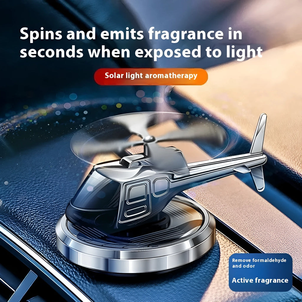 Metal solar helicopter car perfume ornament with rotating blades on a car dashboard.