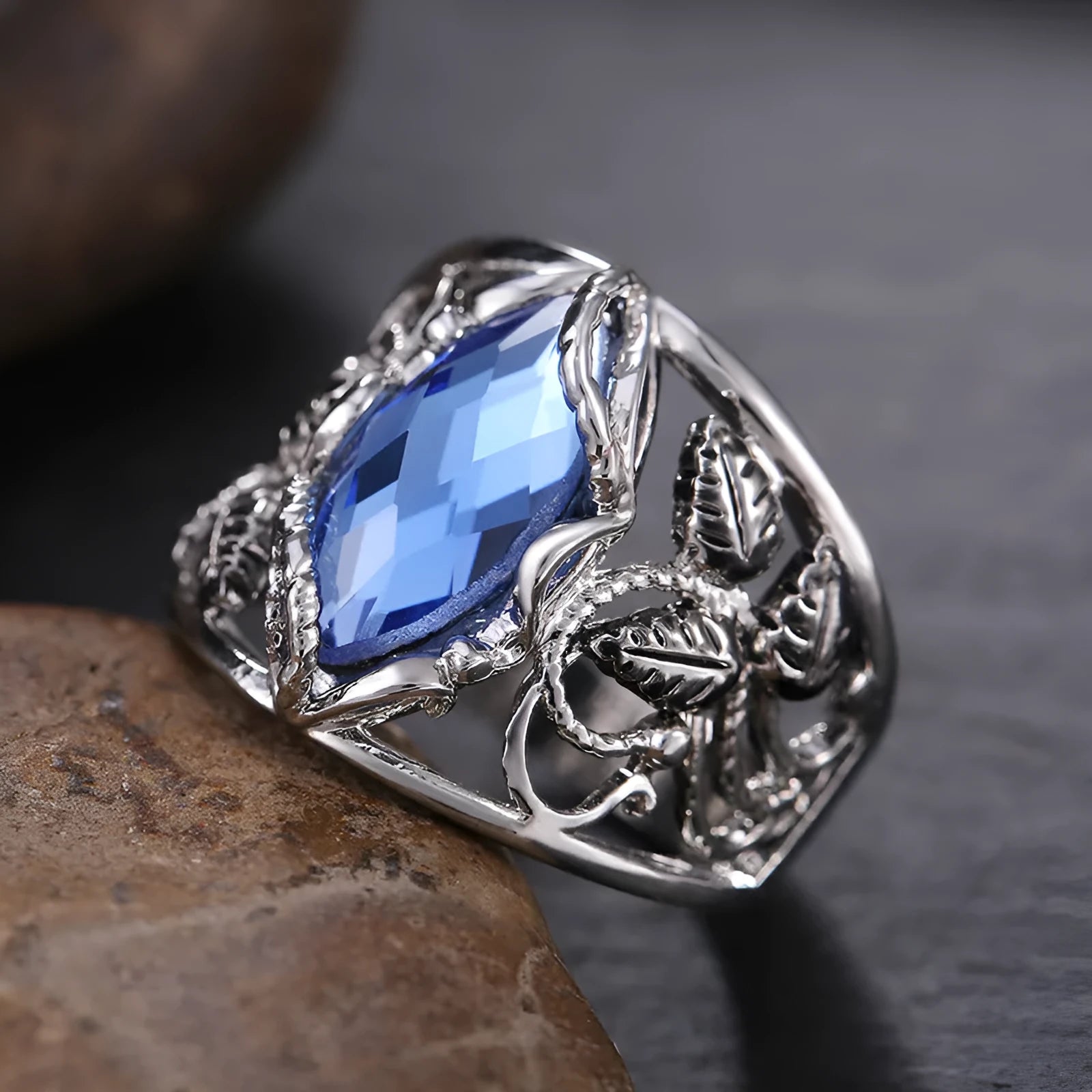 Blue crystal inlay horse eye-shaped geometric alloy ring for women on a plain background.