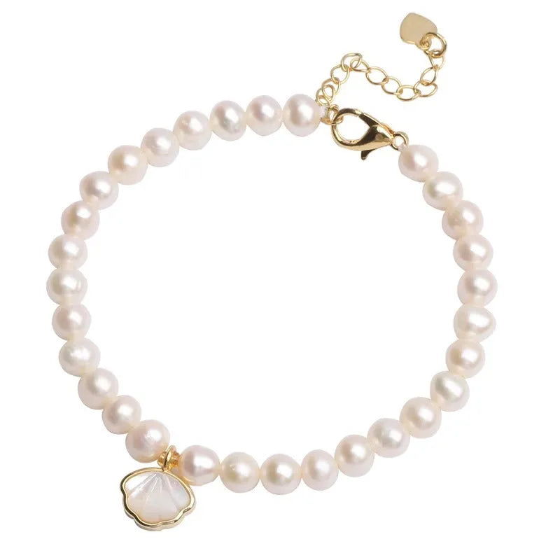 Women's fan-shaped freshwater pearl bracelet on wrist showing elastic string and extension chain options