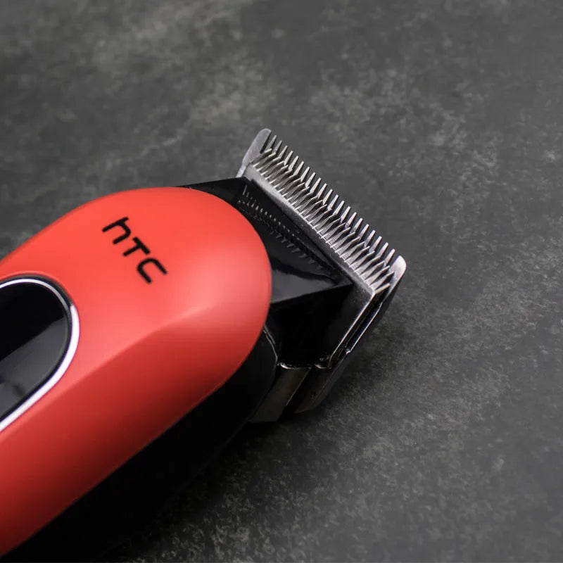 Professional black rechargeable hair clipper with four plastic limiting combs and accessories on a white background.