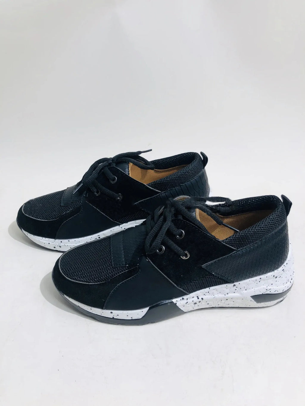 Women's black casual sneakers with a suede upper and a low wedge heel on a plastic sole.