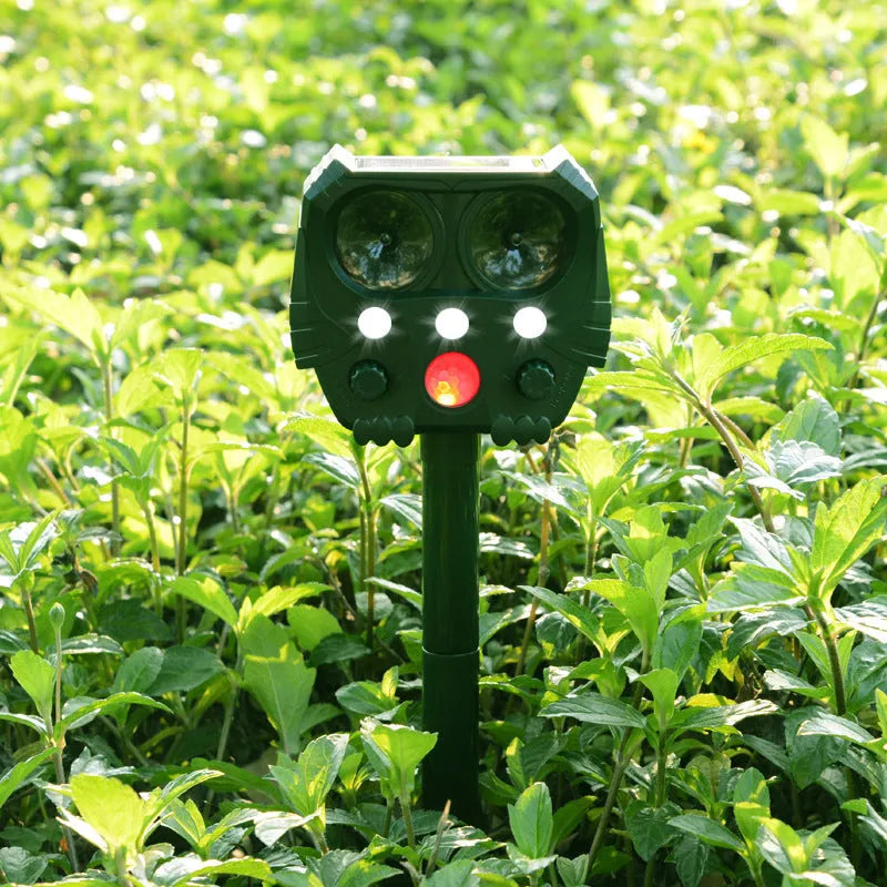 Green solar-powered ultrasonic animal repeller with motion sensor on a white background.
