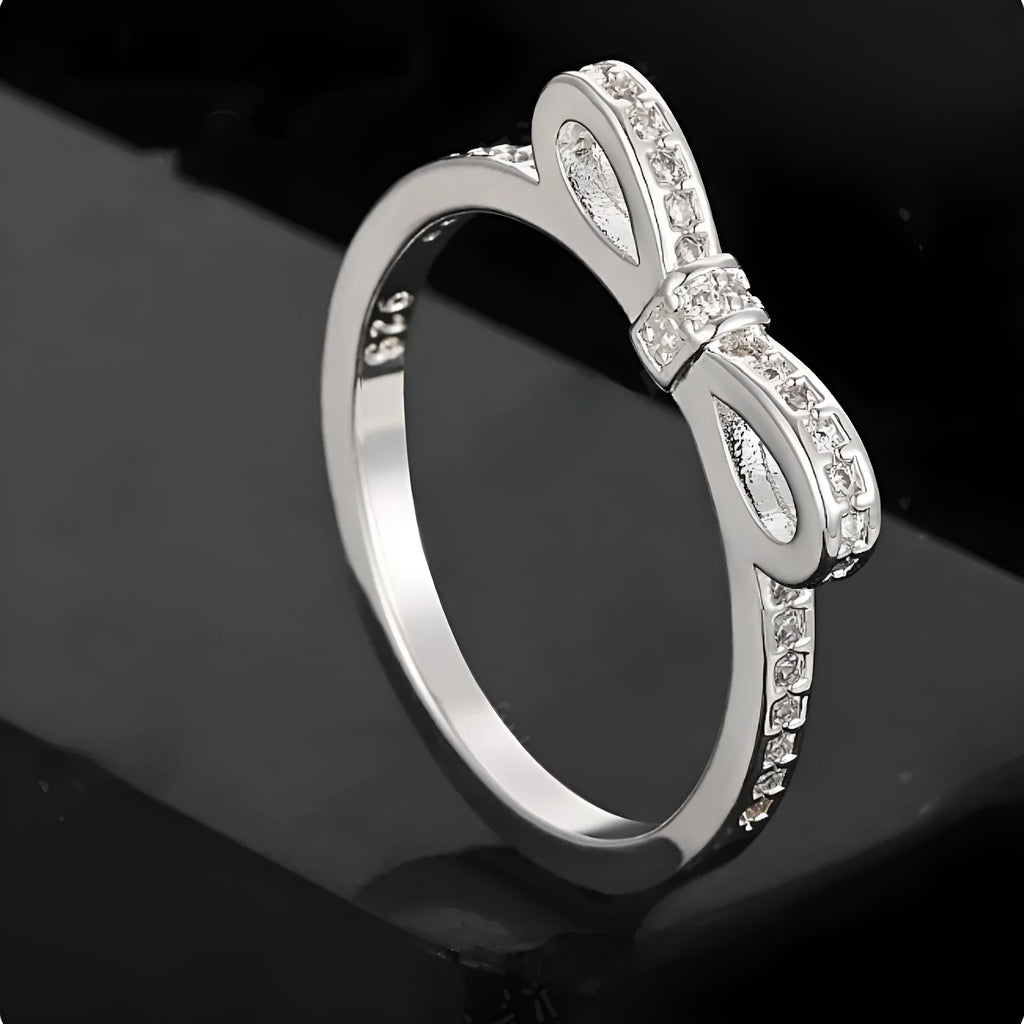 Silver bow-shaped ring with rhinestone and zircon crystal decoration on model hand