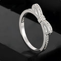 Silver bow-shaped ring with rhinestone and zircon crystal decoration on model hand