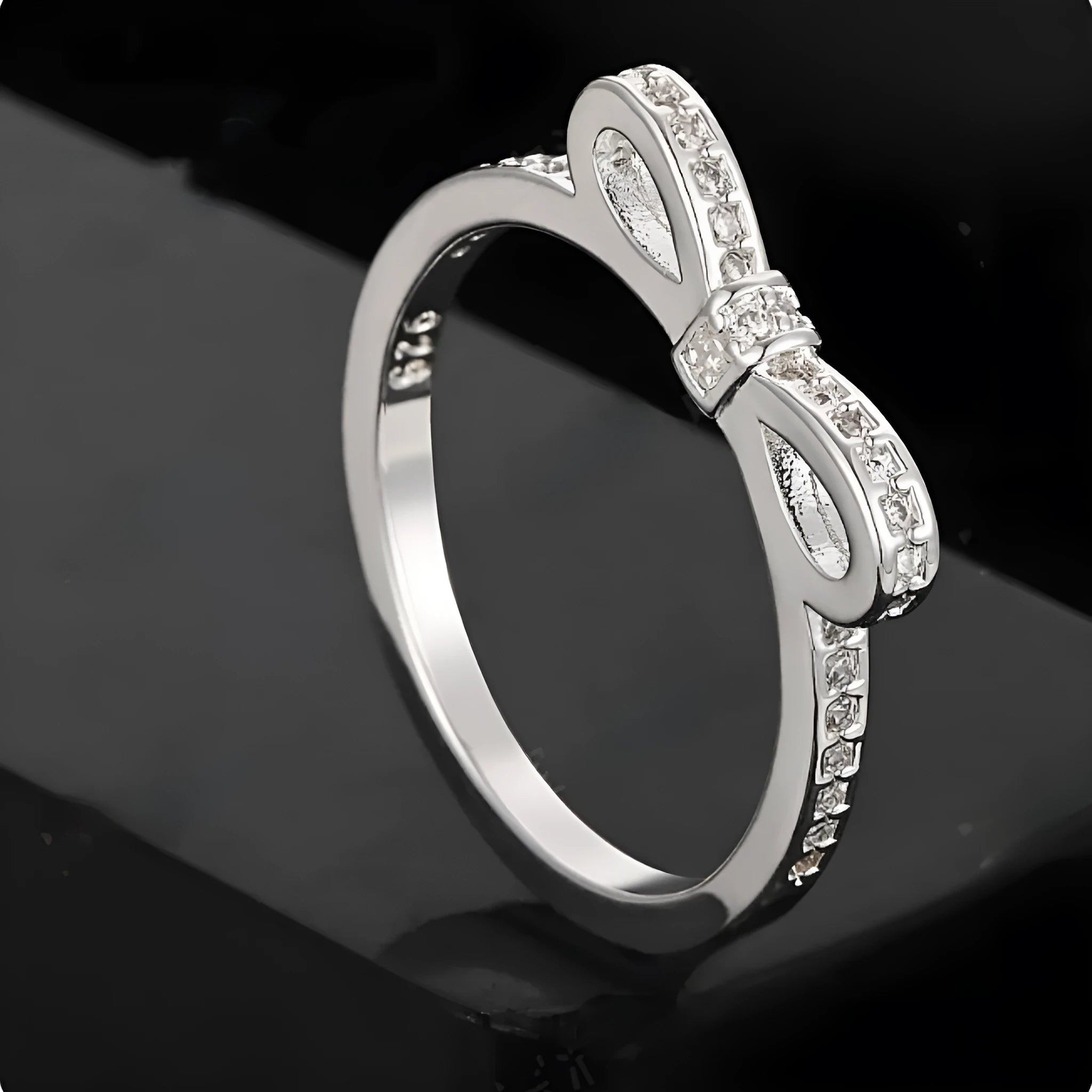 Silver bow-shaped ring with rhinestone and zircon crystal decoration on model hand