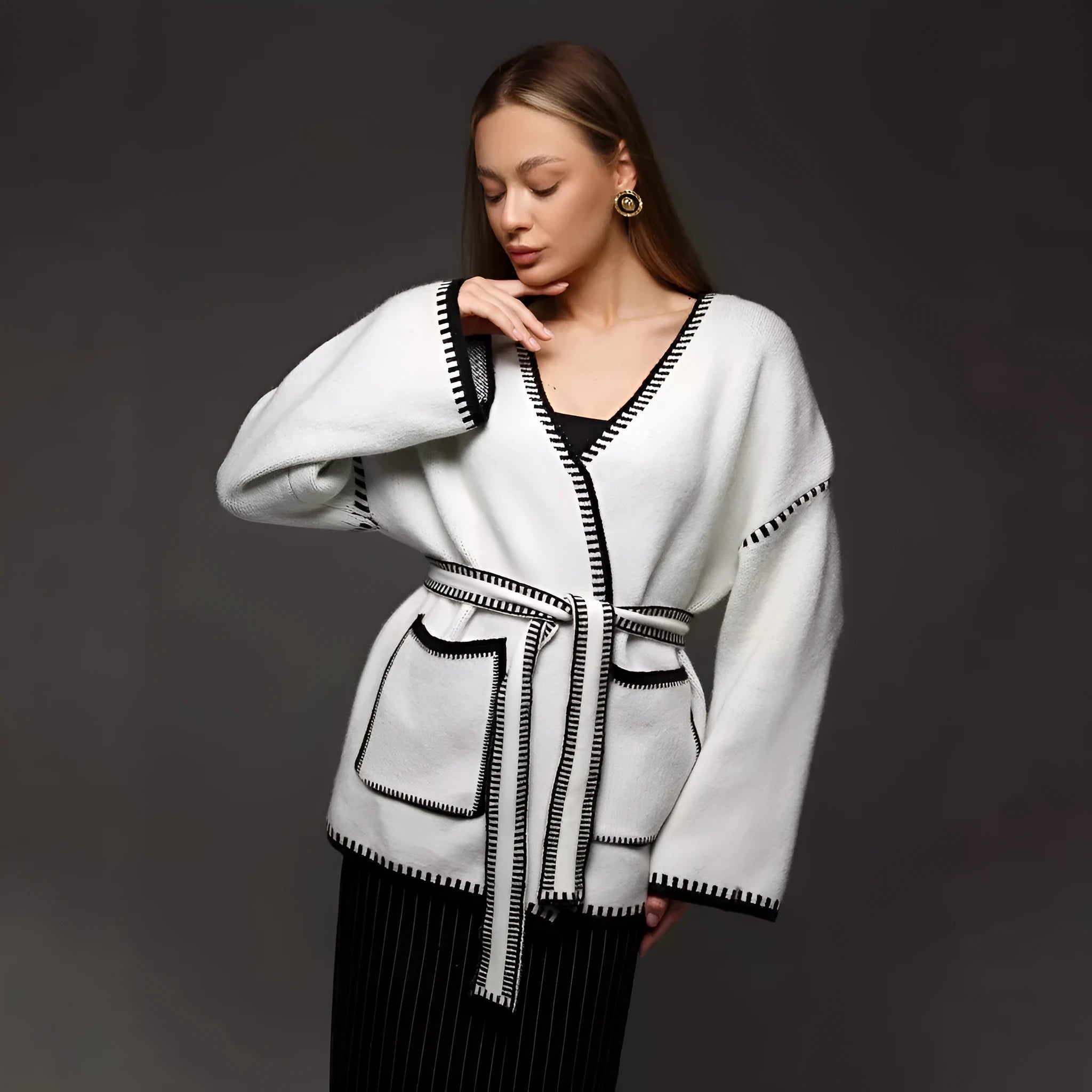 Loose fit knitted cardigan sweater in black, camel, or white colour on a hanger