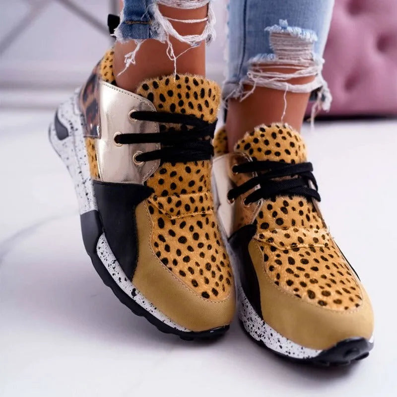 Women's black casual sneakers with a suede upper and a low wedge heel on a plastic sole.