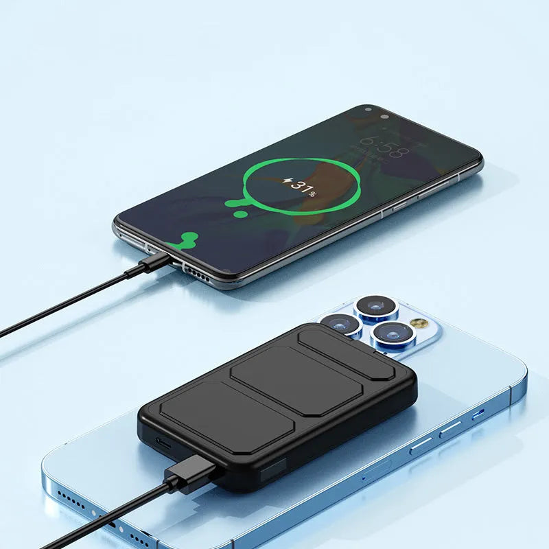 Silver magnetic wireless charging power bank with folding stand unfolded, shown next to a smartphone.