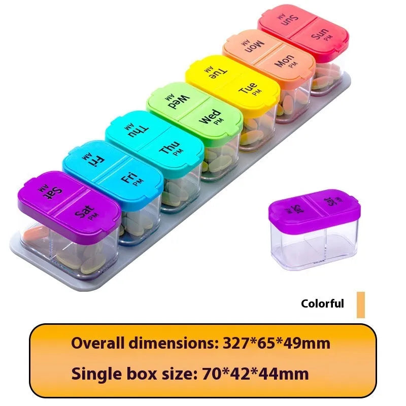 Extra large white plastic pill dispenser with 14 removable rainbow-coloured grid compartments open on a table.