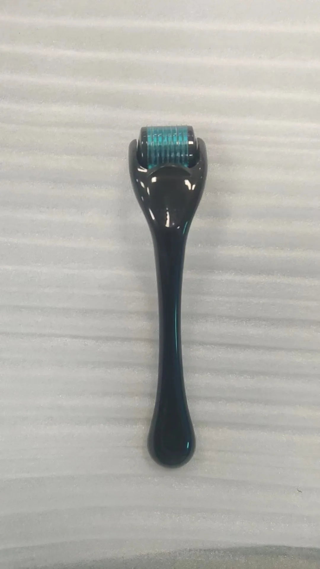 Sterile 540 micro needle derma roller showing handle and needle wheel in assorted colours.