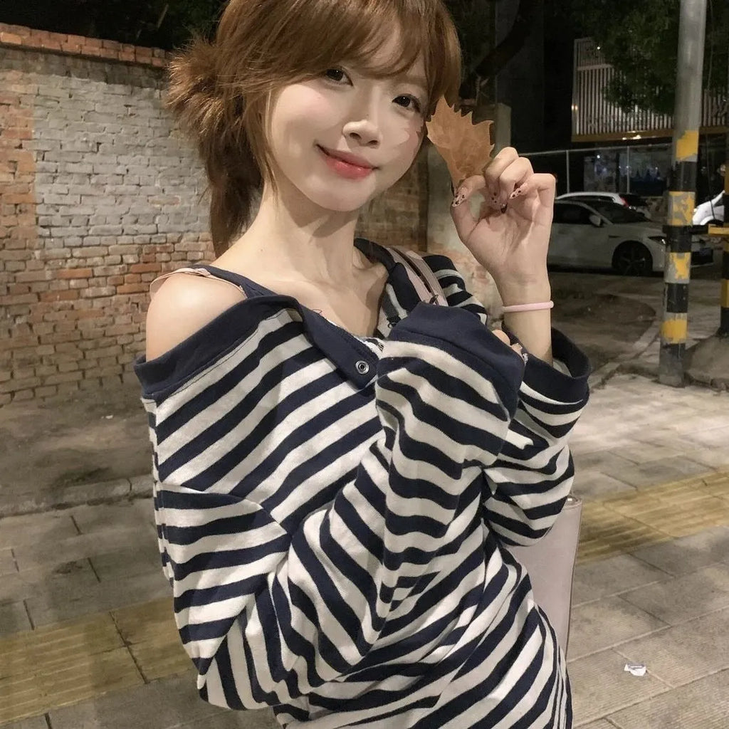 Dark blue women's long-sleeved oversized T-shirt with embroidery and striped detail on a hanger.