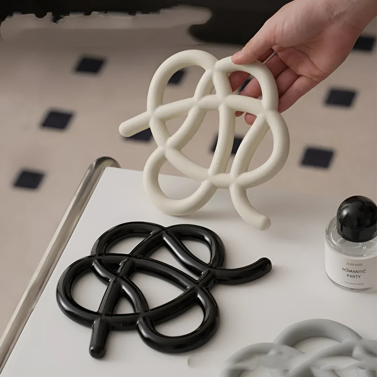 Ceramic heat proof mat in an irregular shape on a wooden table.