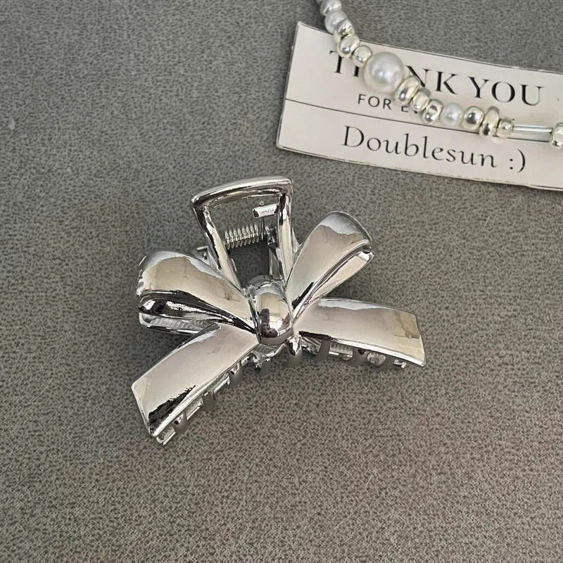 Silver electroplated metal hair claw barrette in a Korean-style design on white background