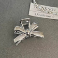 Silver electroplated metal hair claw barrette in a Korean-style design on white background