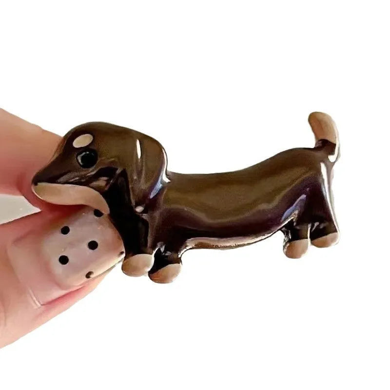 A pair of cute Dachshund dog hair barrettes with a loose, delicate design on a white background.