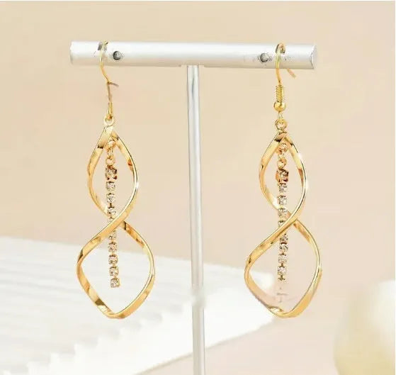 Gold colour female earrings with creative spiral design and geometric ellipse shape