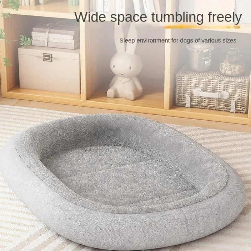 A grey thickened pet kennel with a fleece cover for a small dog resting inside on a wooden floor.