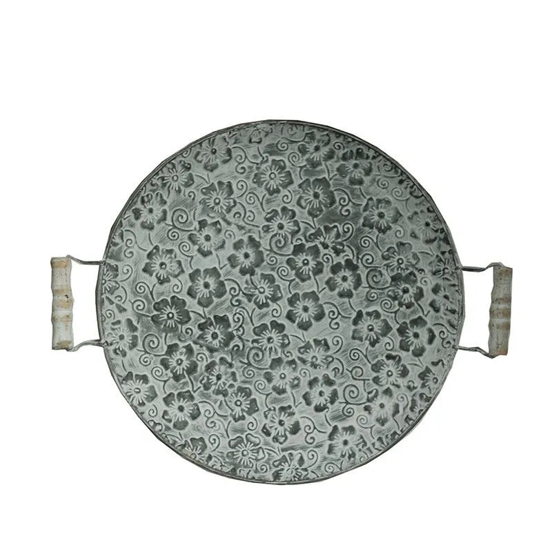 Round wrought iron storage trays in two sizes on a wooden surface