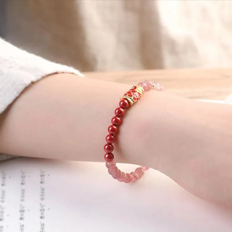 Women's bracelet with purple cinnabar and pink strawberry quartz beads, koi design, on wrist.