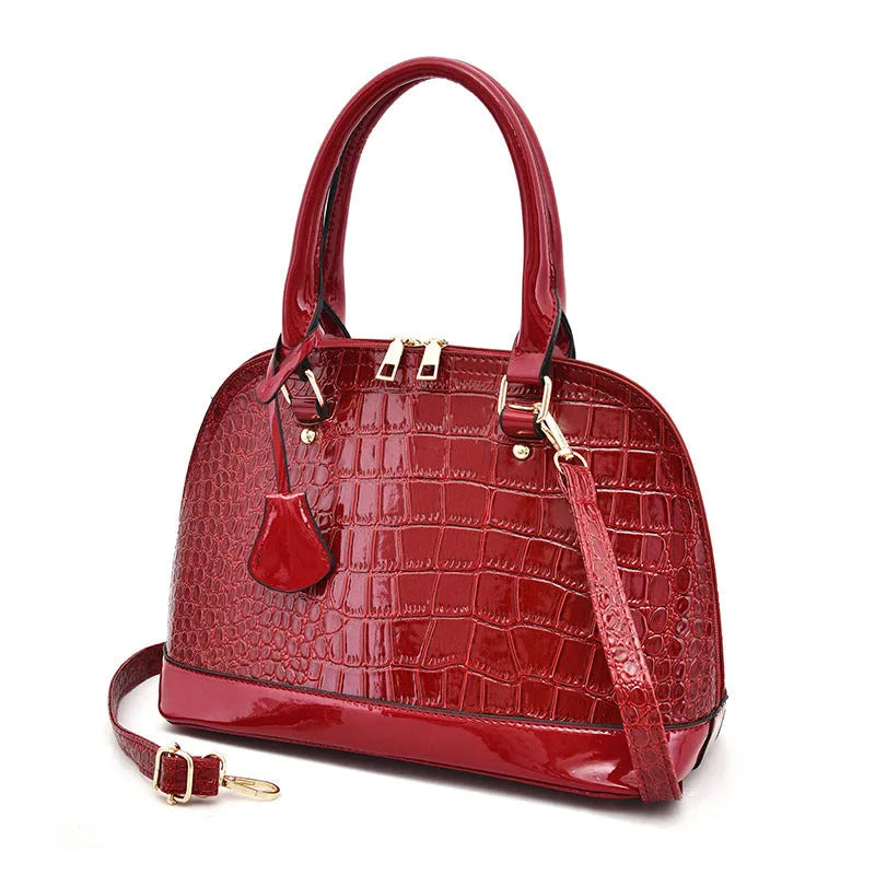 Shell-shaped shiny PU leather crossbody shoulder bag showing black, brown, and red colour options