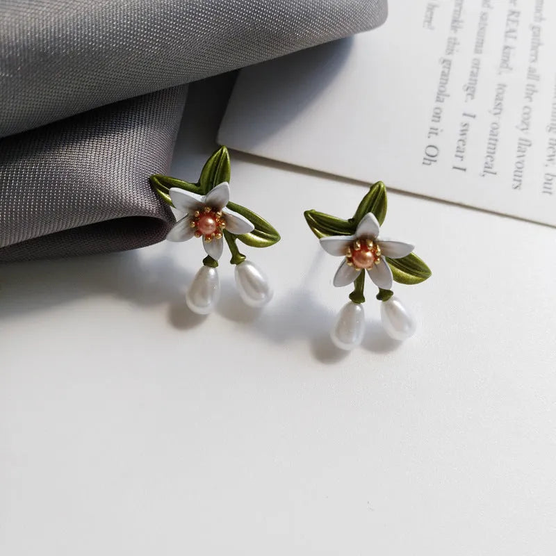Women's alloy flower earrings showing sterling silver needle detailing on studs and contrast colours on clips