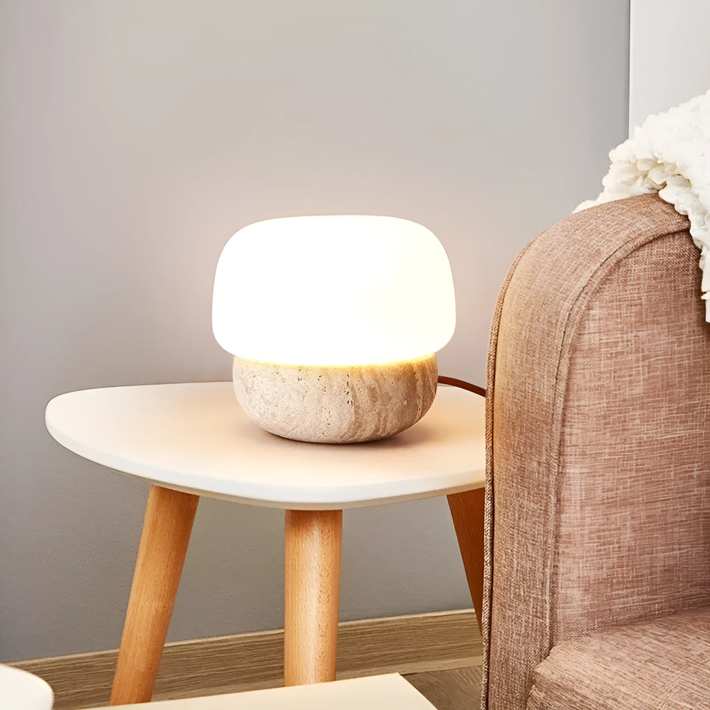 Cream coloured retro bedside lamp with a button switch on a wooden surface.