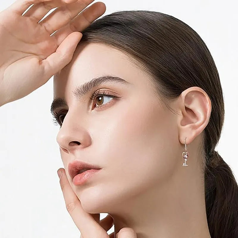 A pair of silver-toned geometric skull earrings for pierced ears on a plain background.