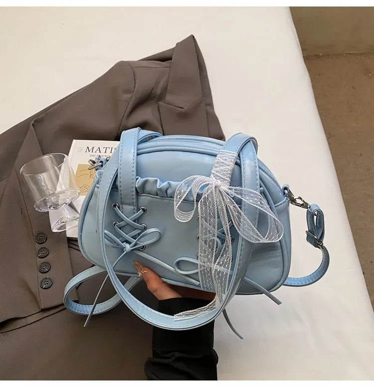 Women's bandage bow handbag in milky white colour with adjustable bow detail and internal mobile phone compartment