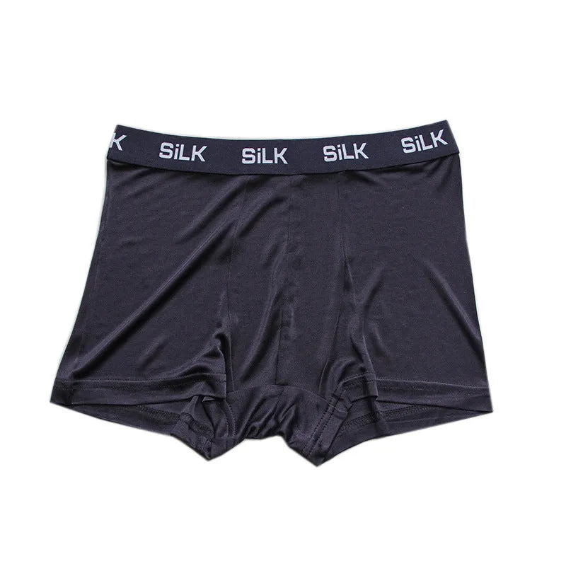 Men's loose-fitting silk shorts in navy blue, shown laid flat to display mid-waist design.