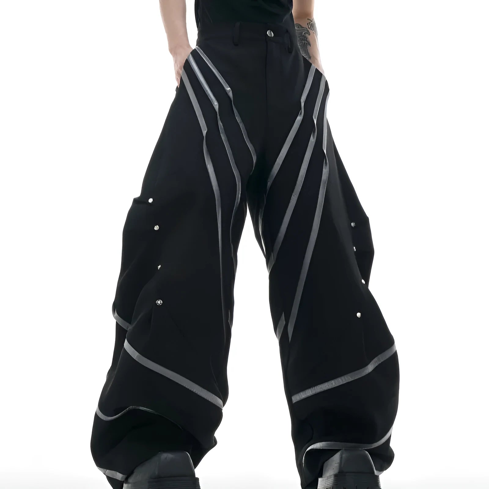 Men's black polyester trousers with metal striped rivets and pleated detail on a white background.
