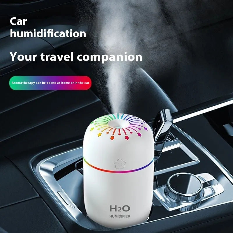Small white, pink, or green USB-powered mini humidifier with water tank on a desk.