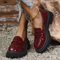 Women's black slip-on loafers with a chunky platform heel and rubber sole.
