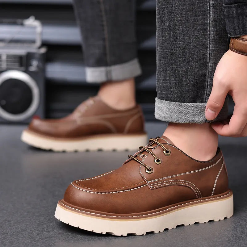 Men's black retro low-top Martin boots with a rounded toe and rubber sole on a plain background.