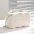 Vertical striped cubic makeup bag in beige with 22.5cm dimensions showing open interior