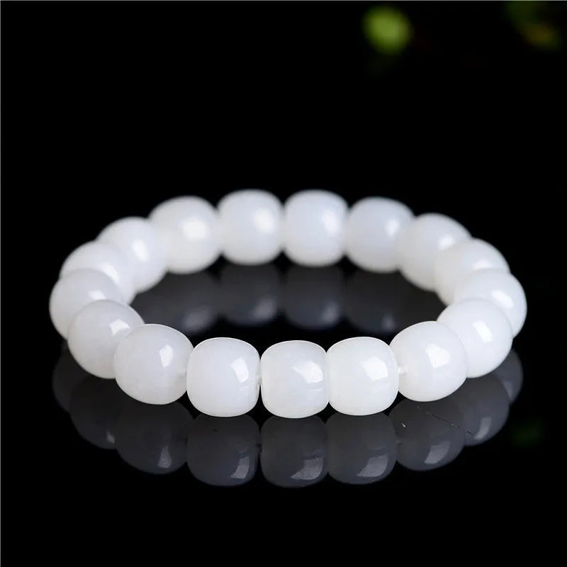 White Hetian jade barrel bead bracelet on a wrist, showing unisex casual style.
