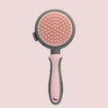 Green two-sided silicone pet brush with retractable slicker pins and a silicone massager head.