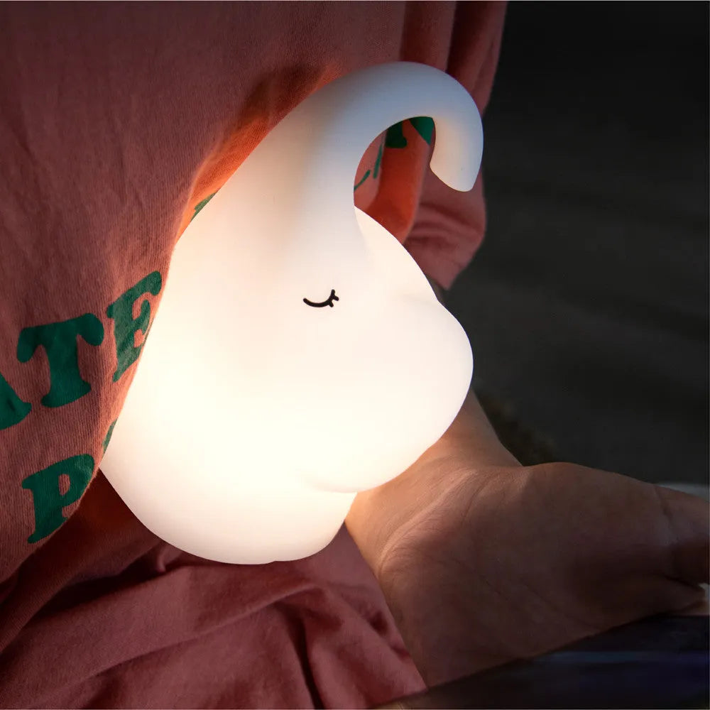 DOMI Elephant-shaped silicone night light with warm white LED glow on a bedside table.