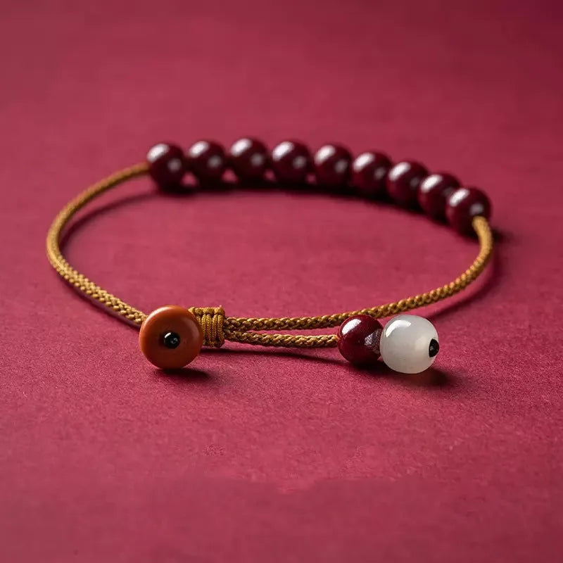 Hand-woven raw cinnabar bracelet with geometric shape on model wrist.