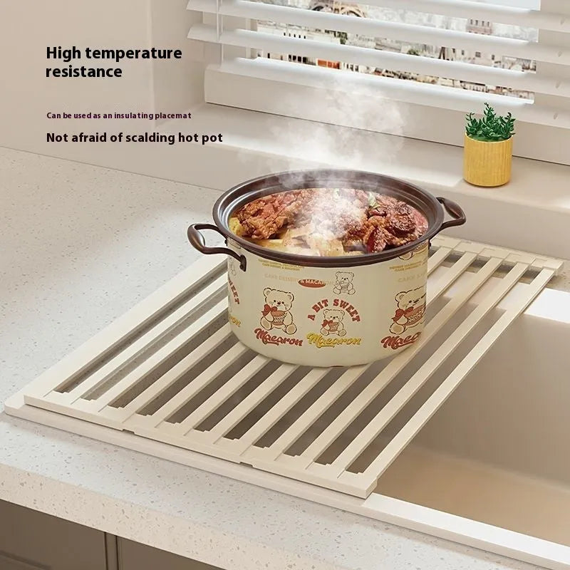Foldable milky white stainless steel kitchen draining rack beside a sink