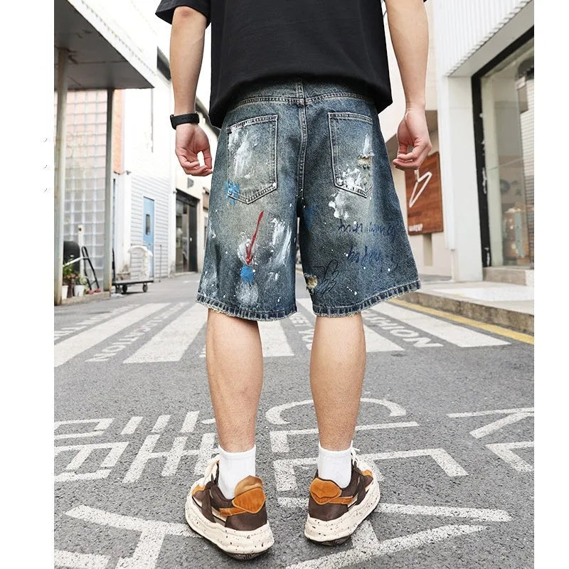 Men's blue ripped jeans shorts with graffiti detail, straight leg cut, and zipper fly closure