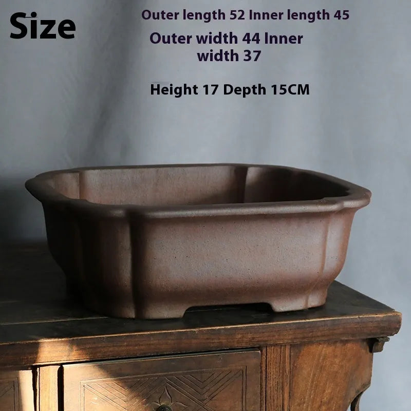 Purple sand rectangular bonsai flower pot on floor with drainage hole visible