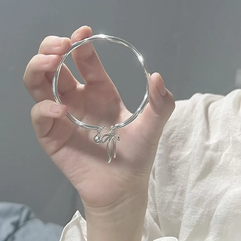 Silver adjustable bracelet with bow decoration and bell opening clasp on zinc alloy chain