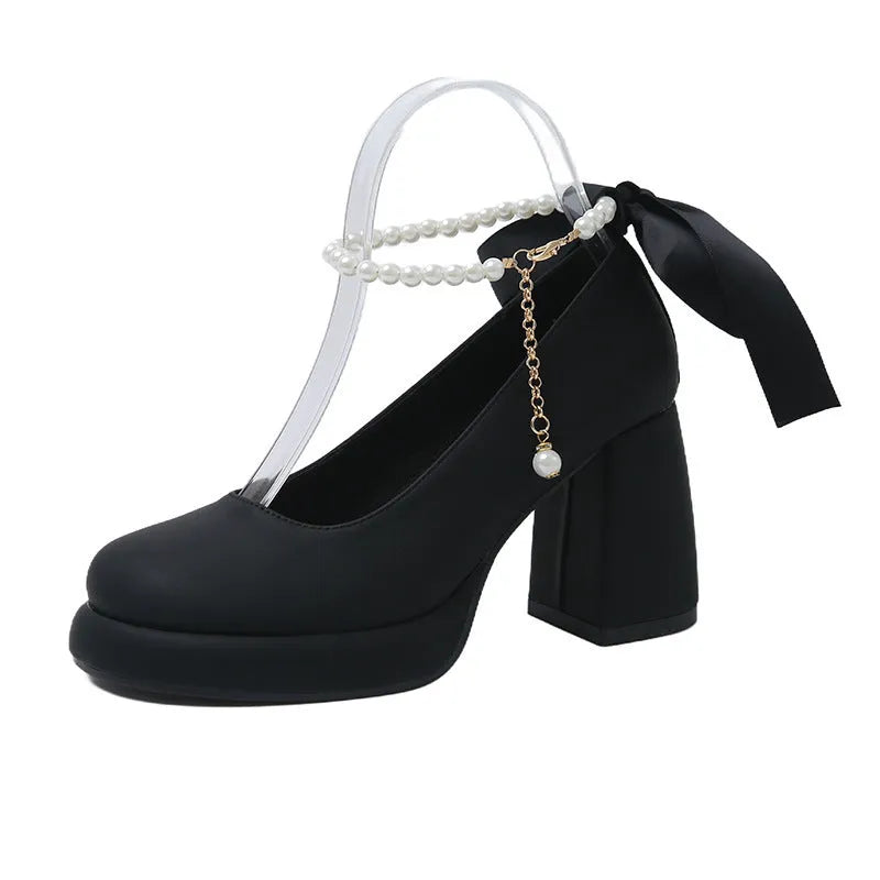 Women's beige Mary Jane shoes with a chunky heel and pearl-embellished ankle-strap buckle on a round toe.