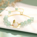 Women's rabbit charm bracelet with green aventurine or strawberry quartz beads, copper and gold accents.