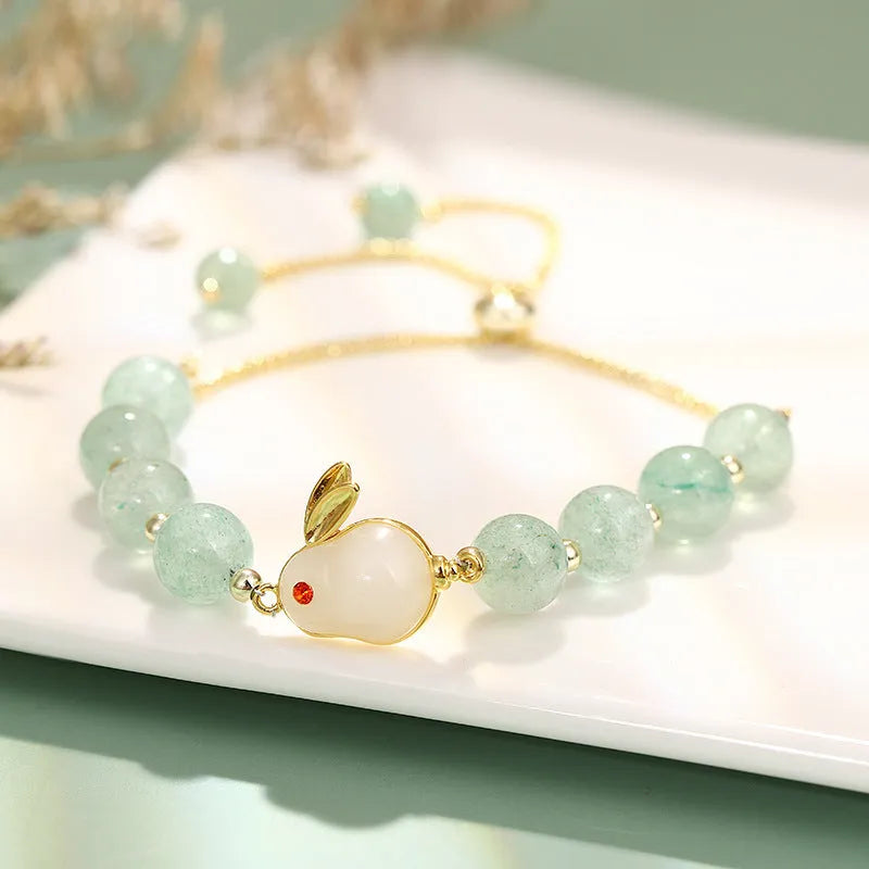 Women's rabbit charm bracelet with green aventurine or strawberry quartz beads, copper and gold accents.