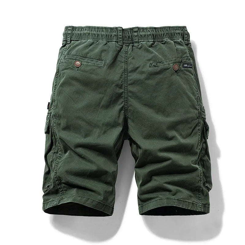 Men's army green cotton shorts with multiple pockets and a Korean-style fit on a neutral background.